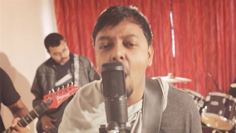 Bijoy Thangaraj performing guitar with a band